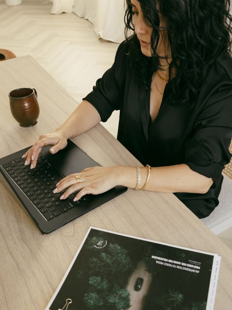 woman sitting behind a desk on her laptop creating content